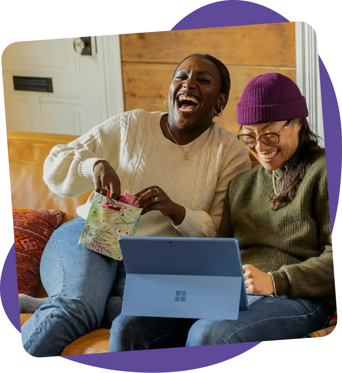 Two people laughing looking at a laptop